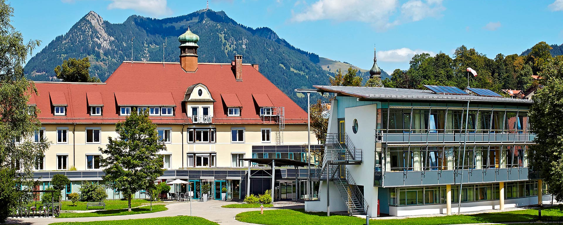 Aussenansicht der Geriatrie-Kliniken Sonthofen vor oberallgäuer Bergpanorama