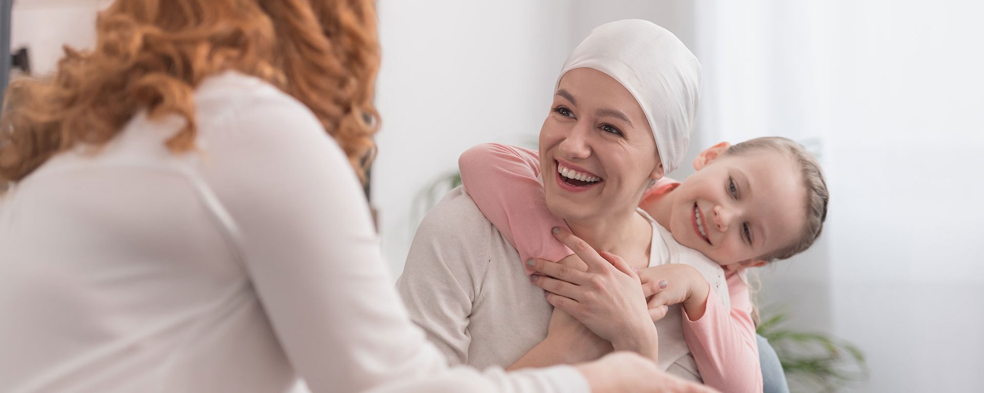 Eine Familie verbringt im Klinikverbund Allgäu Zeit zusammen. Ein kleines Kind umarmt Ihre Mutter.